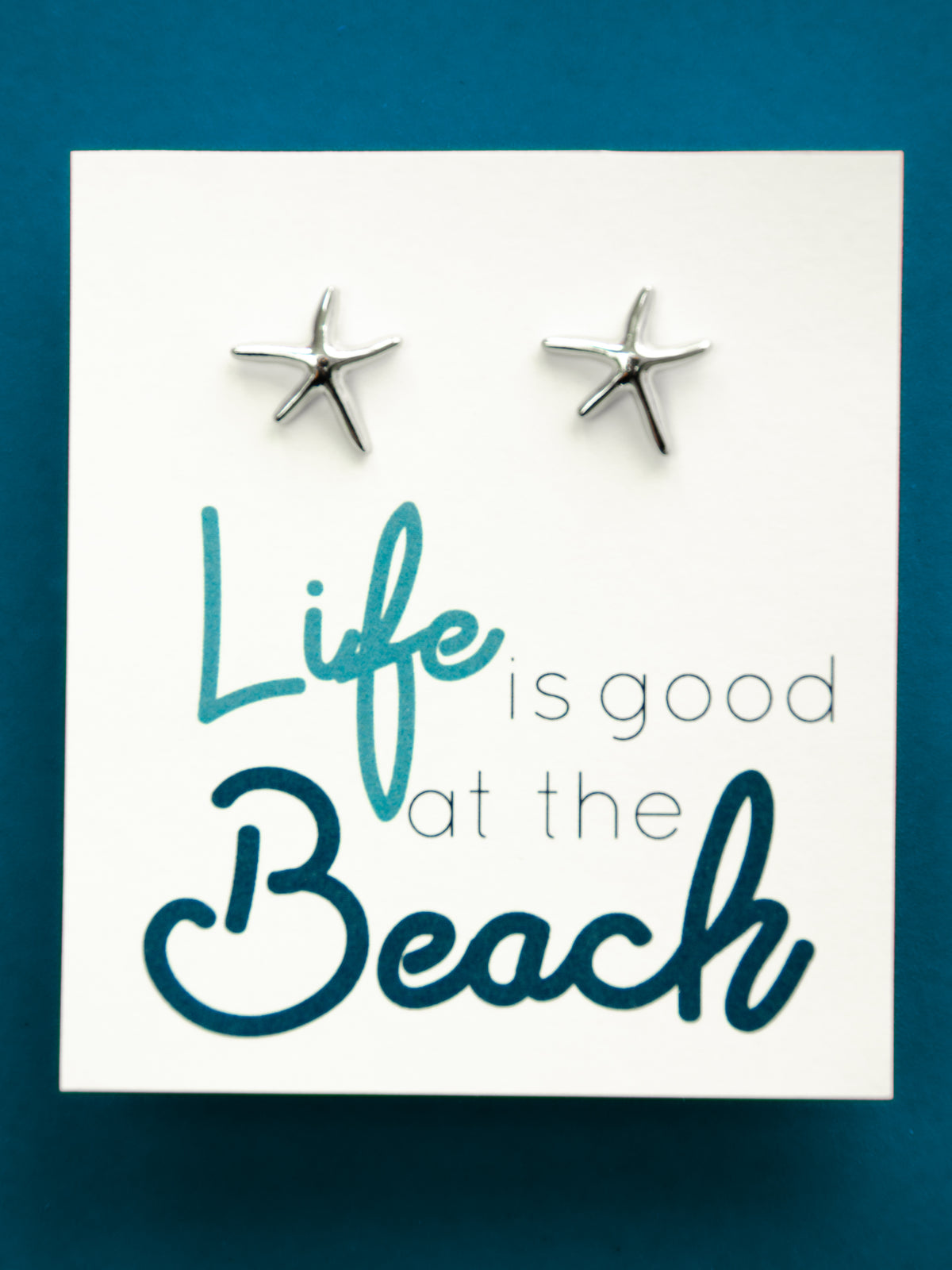 life is good at he beach silver starfish earrings on a 3.5 x 3.5 card with black box