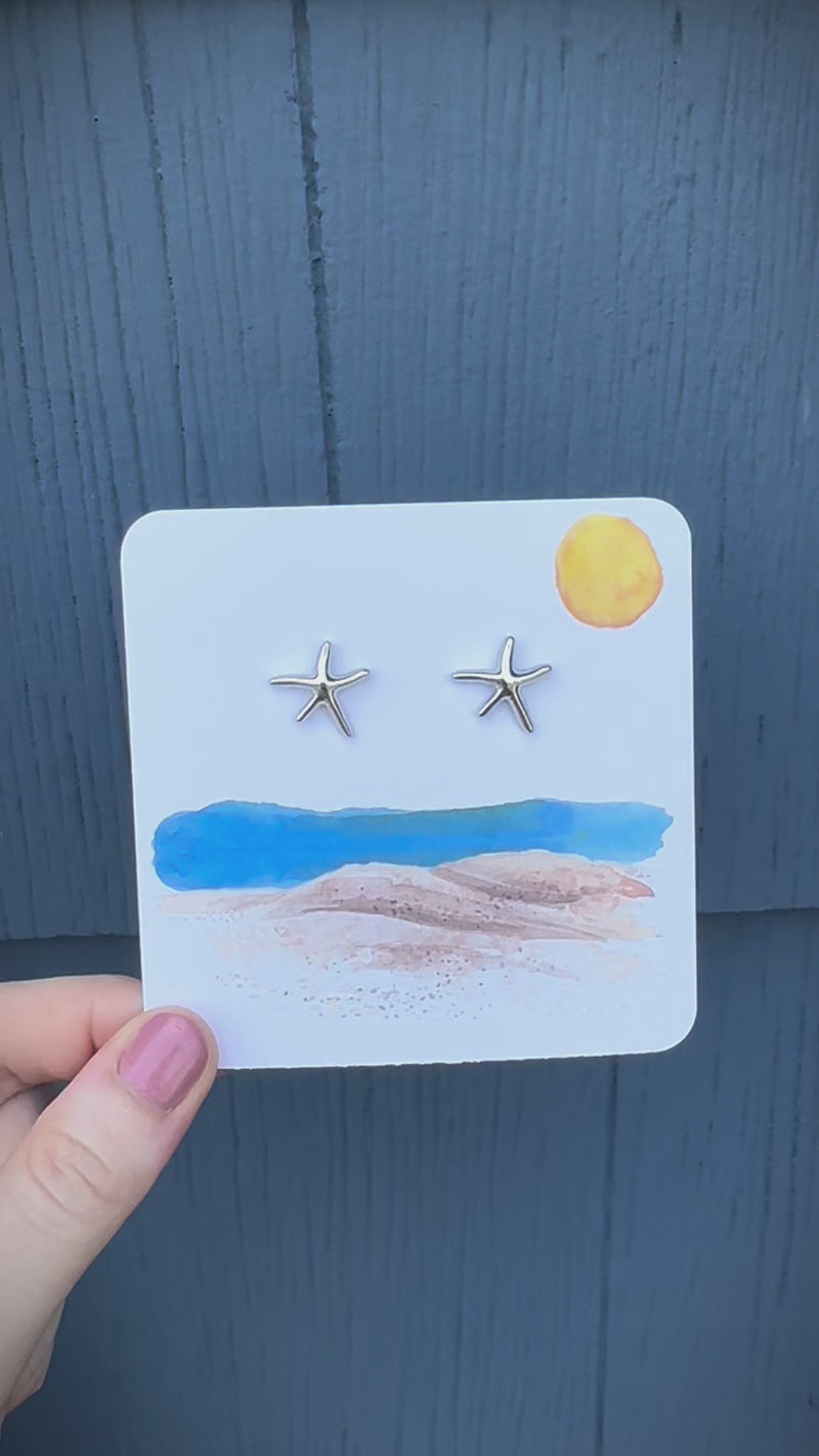 silver starfish stud earrings on beach card